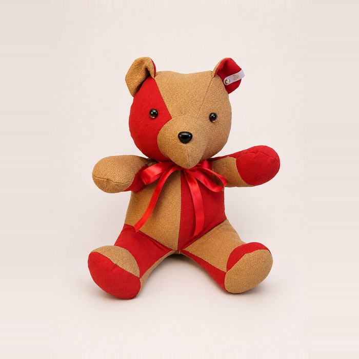 Memory bear in red and tan patchwork with a red ribbon