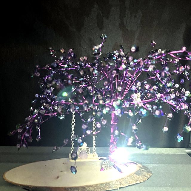 Purple memory tree lit up, with a tiny swing